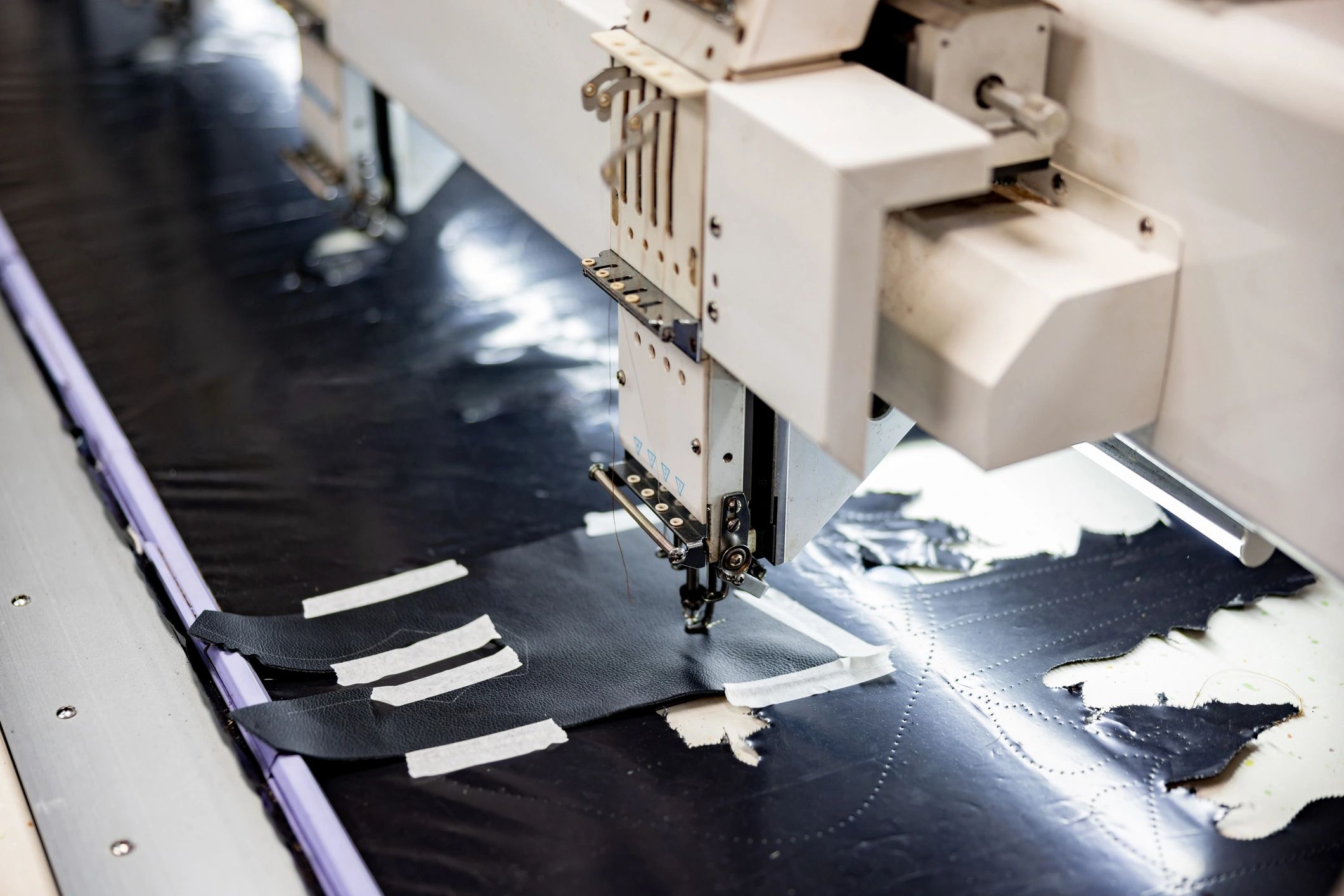 Sewing machine stitching material in a workshop